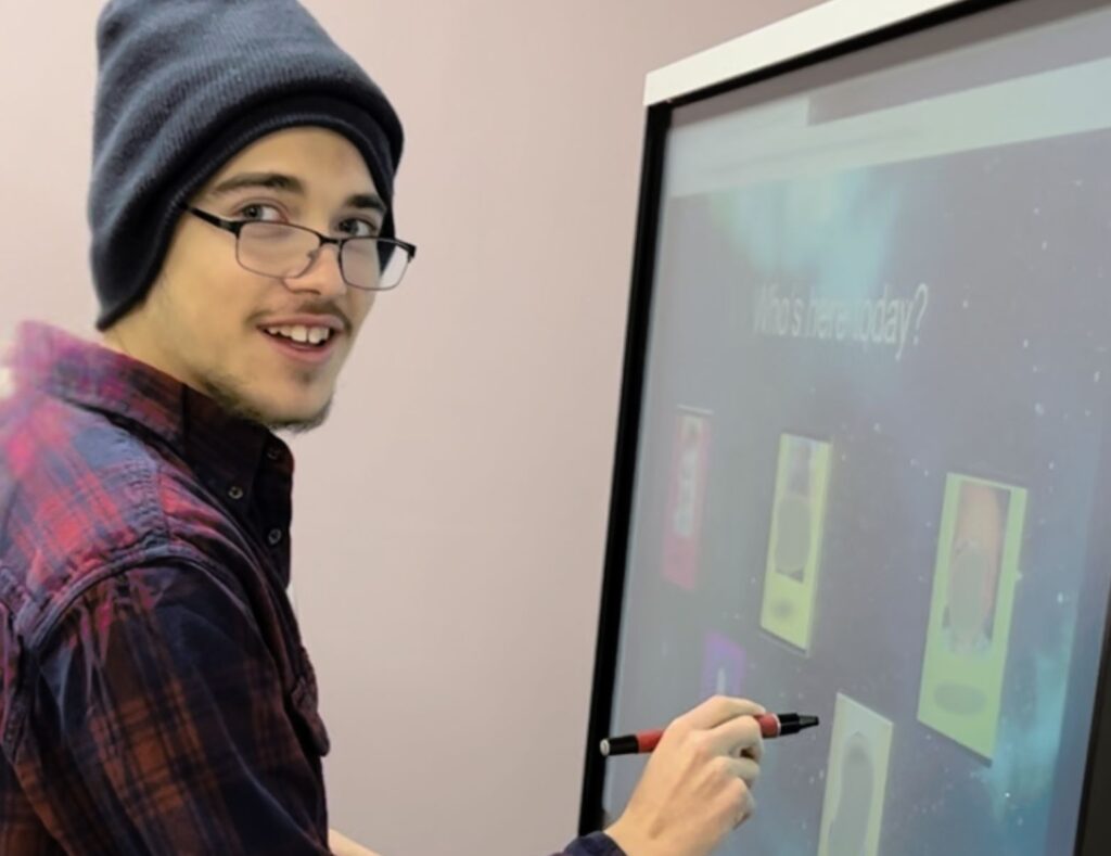 RCS Learning Center student writing on Smarboard as part of autism education programming.